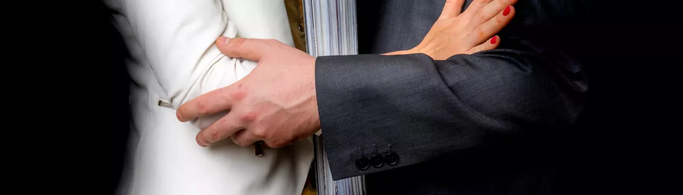 Man touching woman's elbow isolated on black - sexual harassment in business office