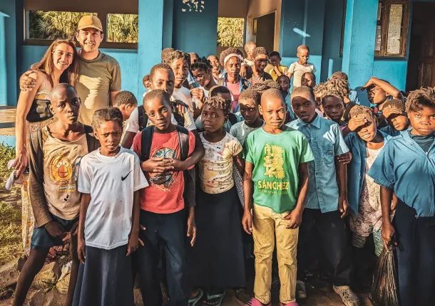 Danny Yadidsion and his wife standing with kids in Africa, where they made a donation to local schools and hospitals