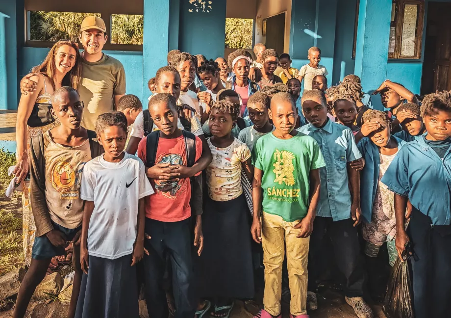 Danny Yadidsion and his wife standing with kids in Africa, where they made a donation to local schools and hospitals