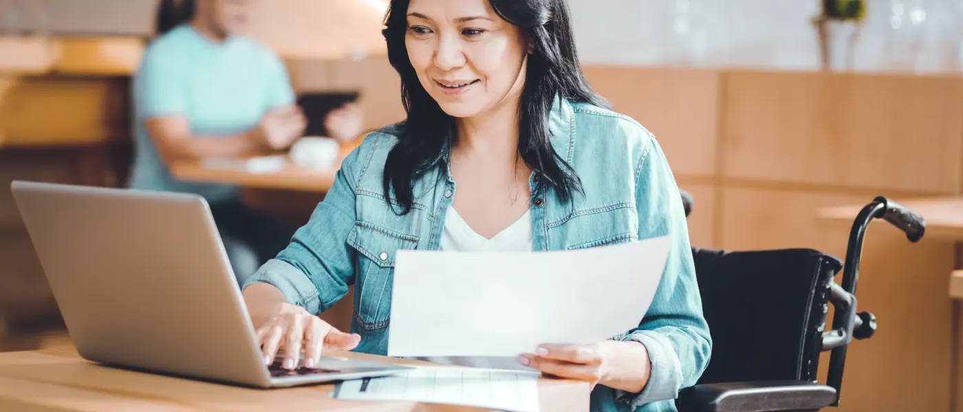 Trabajo a distancia. Mujer responsable discapacitada trabajando a distancia en una cafetería.